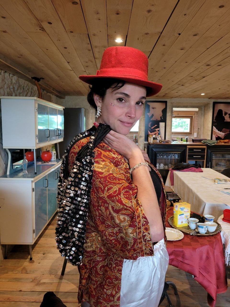Une artiste au chapeau rouge, un châle sur l'épaule