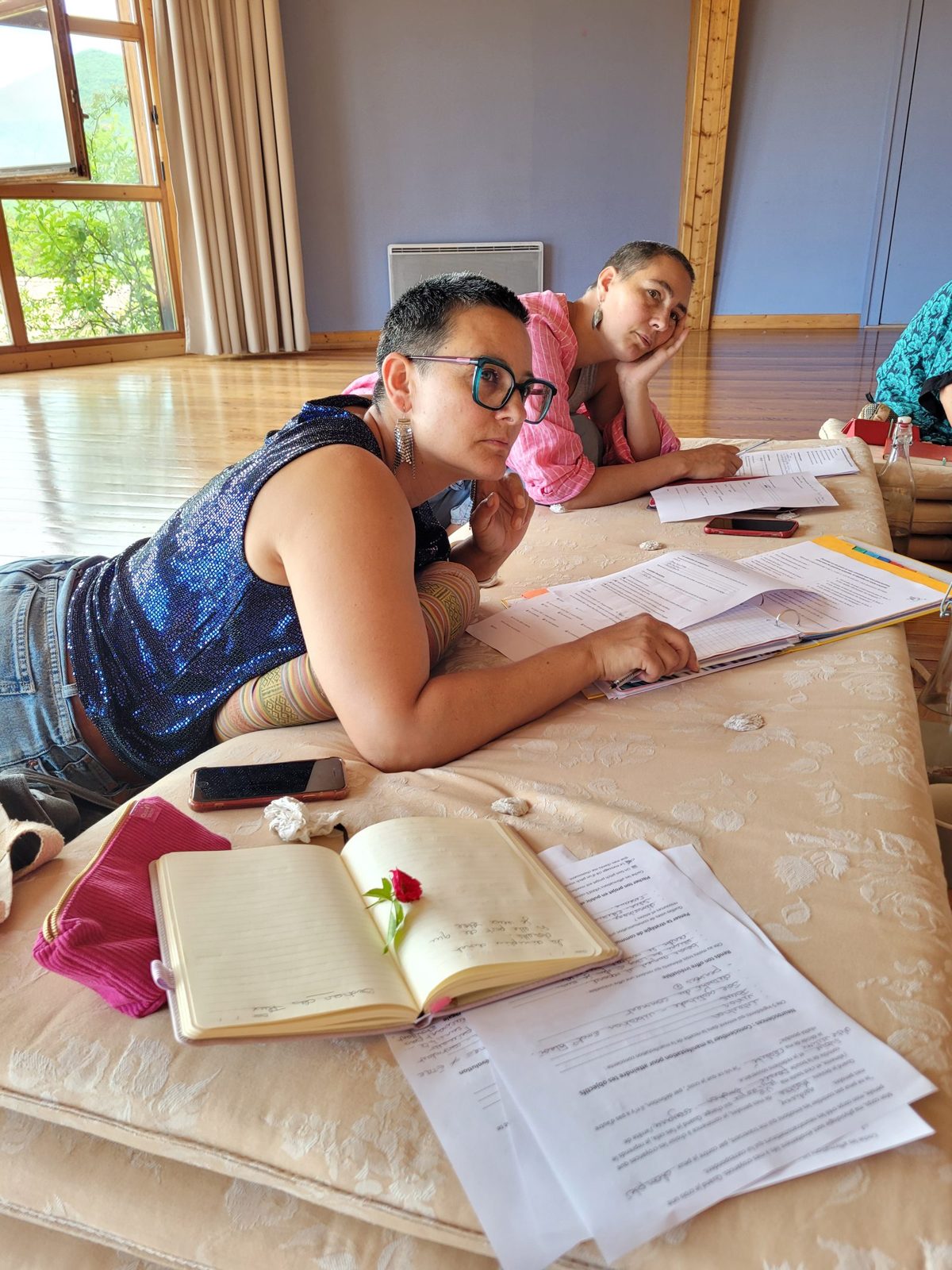 Deux participantes allongées sur les matelas, carnets ouverts