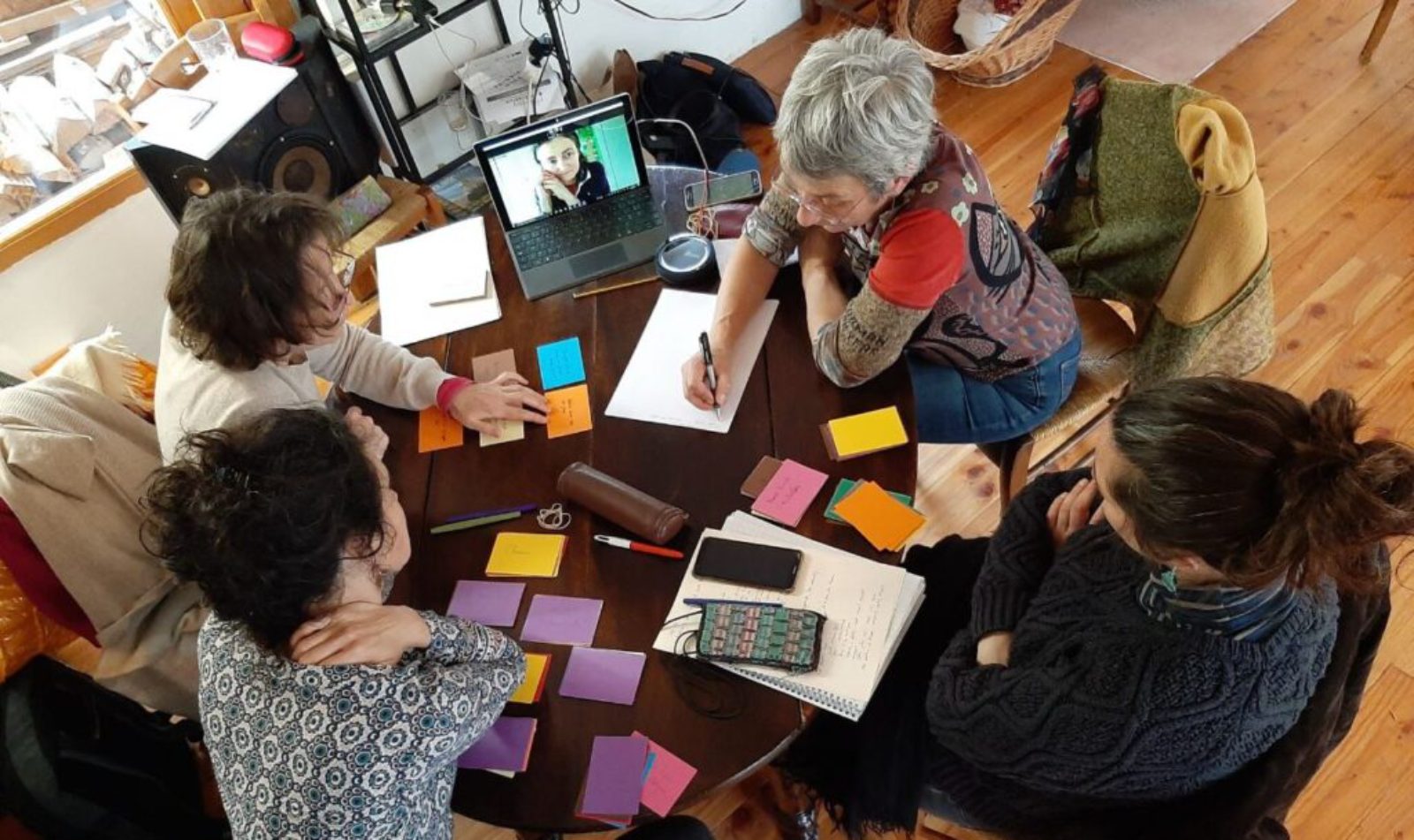 Quatre participantes autour d'une table couverte de post-it