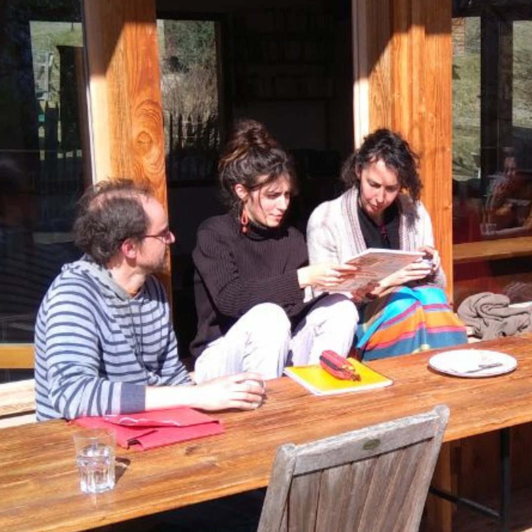 Trois personnes autour d'une table, un livre ouvert